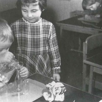Travasi The little boy is very deliberately and carefully pouring water from one container into another, trying to avoid spilling any. He practises distributing the liquid into different containers, into wide and narrow openings. Soon he will be able to pour drinks from any container at all, or water the plants. Berlin Children's House, 1961 - T. Müller, R. Schneider, <em>Lehrmaterialien 1913-1935. Möbel und Architektur. Techning Meterials 1913-1935. Furniture and Architecture</em>, München, Prestel Verlag, 2002, p.81$$$424