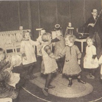 Musica e danza Music and dance in a Children's House on Leopoldplatz, Berlin-Wedding. Postcard published by the DMG (German Montessori Society), around 1927. The boy and girl in the bottom left-hand corner of the picture are accompanying their teacher, who is playing the violin, on the triangle and tambourine - T. Müller, R. Schneider, L<em>ehrmaterialien 1913-1935. Möbel und Architektur. Techning Meterials 1913-1935. Furniture and Architecture</em>, München, Prestel Verlag, 2002, p.24.$$$369