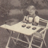 Tavolette bariche Girl judging the weight of the baric sense tablets, Children's House, Berlin-Lankwitz 1919-22. Postcard published by the DMG (German Montessori Society), around 1927, with the inscription: "If a child has worked - even for a long time - at an exercise he has chosen freely we find that he is happy and relaxed afterwards, not exhausted." Photograph: Clara Grunwald - T. Müller, R. Schneider, <em>Lehrmaterialien 1913-1935. Möbel und Architektur. Techning Meterials 1913-1935. Furniture and Architecture</em>, München, Prestel Verlag, 2002, p.94$$$456