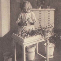 Cura delle piante Looking after flowers in a Berlin Children's House. Postcard published by the DMG (German Montessori Society), around 1927 - T. Müller, R. Schneider, <em>Lehrmaterialien 1913-1935. Möbel und Architektur. Techning Meterials 1913-1935. Furniture and Architecture</em>, München, Prestel Verlag, 2002, p.85$$$435